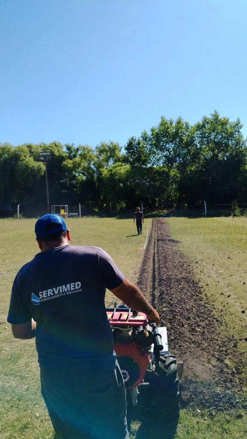Técnico de SERVIMED abriendo una zanja con una zanjadora en un campo
